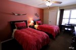Guest bedroom offers two twin beds and a desk work area